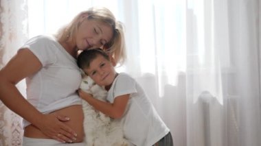Müstakbel anne, elinde sevimli bir oğlanla odada beyaz perdelerin arkasında
