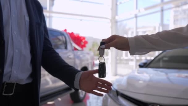 Auto business, de handen van de verkoopster geven sleutels aan de eigenaar van de auto en schudt handen close-up tijdens de succesvolle aankoop in het verkoopcentrum — Stockvideo