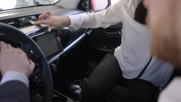 Verkoopster adviseert klant na geeft sleutels aan auto koper en schudt de handen zitten in de cabine bij dealer — Stockvideo