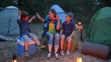 Ormanda kamp yapan aile, anne ve iki çocuk saman balyasının yanında oturuyorlar, anne ve çocuklar.