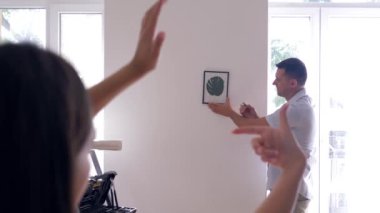 İç dizayn, yakışıklı erkek resim yaparken kız parmaklarıyla çerçeve yapıyor ve duvarlara süsleme yapmaya karar veriyor.