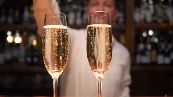 Male barman throws an wedding ring in goblet with champagne in cafe — Stock Video