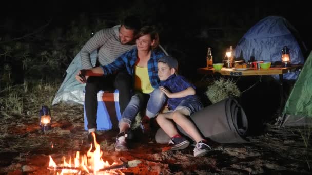 Camping, padres jóvenes con el niño en el campamento de viaje hacer foto selfi, madre y padre con el hijo fotografiado — Vídeos de Stock