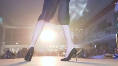 elbise şovu, yüksek topuklu podyum modelleri siyah şeffaf elbiseler içinde podyumda yürüyorlar yeni tasarımcı koleksiyonunun sunumunda projektör ışığına