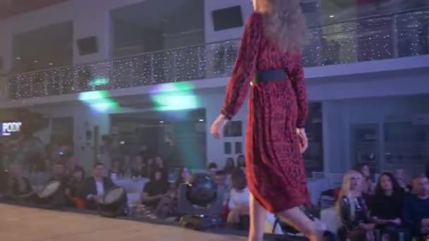 Espectáculo profiláctico, modelos profesionales hembra en vestido coleccionable camina por la pasarela durante la presentación de la nueva ropa de diseñador en el evento de moda — Vídeo de stock
