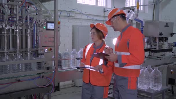 Portrait de travailleurs d'usine heureux hommes et femmes en casques et salopettes près de la ligne de convoyeur avec des comprimés dans les mains pendant le travail acharné — Video