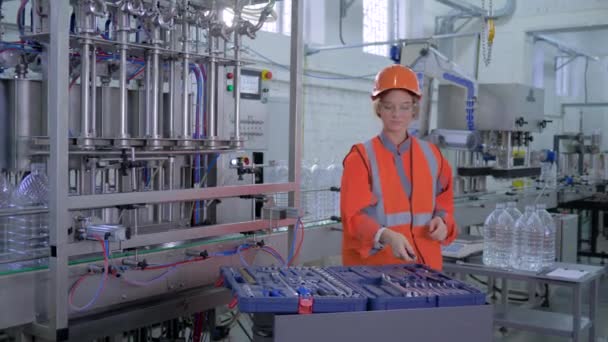 Retrato de mulher engenheiro na fábrica, fêmea feliz forte em vestuário de trabalho e capacete profissionalmente reparos linha transportadora com ferramentas na planta — Vídeo de Stock