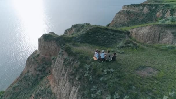 Glad helg, glada grupp vänner att ha kul och spela musikinstrument sträng samtidigt koppla av på picknick utomhus på berget nära floden, antenn undersökning — Stockvideo