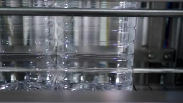 Пластиковые бутылки с чистой водой на автоматической линии ленты на предприятии завода — стоковое видео