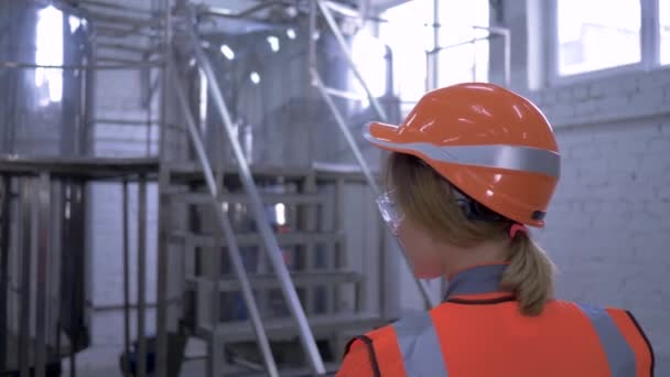 여자들의 기술적 인 직업, 투구를 쓰고 있는 튼튼 한 여자 기술자가 공장의 장비를 통제 한다 — 비디오