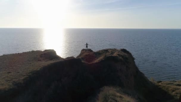 Outdoor-Sportübungen, Silhouette von Männern am Hang am Meer mit brillantem Wasser gegen den Himmel im hellen Sonnenstrahl — Stockvideo