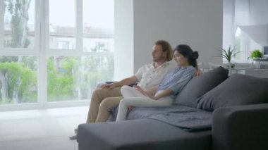Mutlu bebek beklerken, sinirli genç bir kadın erkeklere hamilelikten bahseder ve kollarını karnına koyar ve müstakbel babası mutlu bir şekilde kanepede oturur.