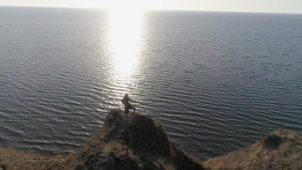 스포츠맨은 밝은 햇볕 아래 하늘을 배경으로 반짝이는 물 근처 산위의 아름다운 자연에 대해 복싱 운동을 한다 — 비디오