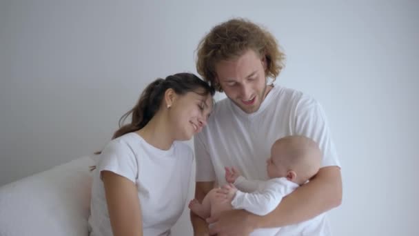 Sielanka rodzinna, szczęśliwa dziewczyna z chłopakiem trzymającym małą dziewczynkę w ramionach i uśmiechającym się w jasnym szpitalu — Wideo stockowe