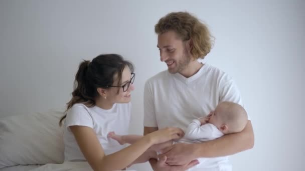 Gelukkig ouderschap, vrolijke vrouw met man houden klein meisje in de armen en glimlach bij moederschap huis — Stockvideo