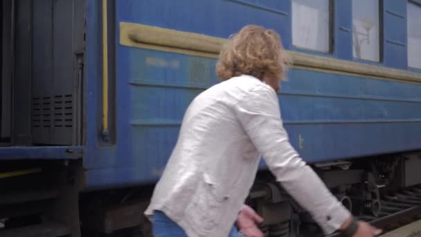 Treffen liebevoller Menschen, glückliche junge Frau umarmt Mann und lacht nach Trennung in der Nähe von Eisenbahnwaggon auf Bahnhof — Stockvideo