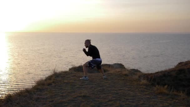 護身術、海の近くの丘で競争する前に拳を練習するボクサー — ストック動画