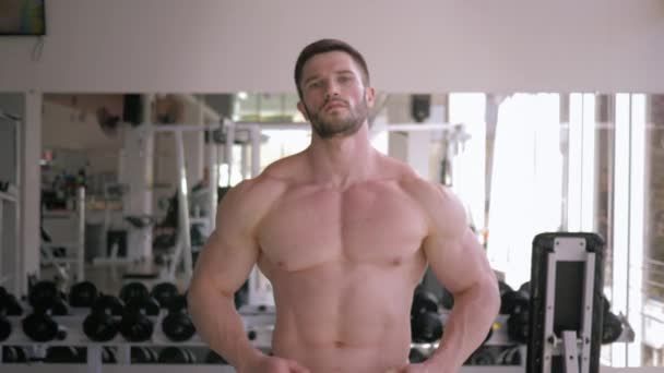 Gezonde levensstijl, sterke bodybuilder guy doet warming-up na krachttraining in het opbouwen van spieren in fitnesscentrum — Stockvideo
