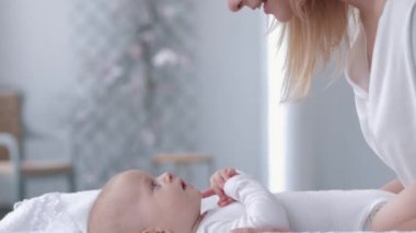 Sevimli anlar, anne öpüyor ve yeni doğmuş bir bebekle eğleniyor.