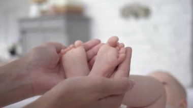 Annelik, annenin şefkatli kolları yeni doğmuş küçük kızın küçük ayaklarını tutun.