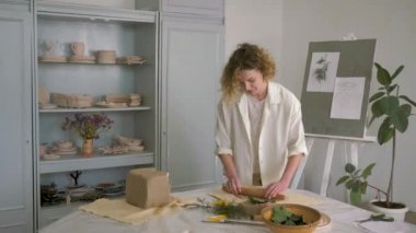 Çömlekçi işçiliği, seramik çanak çömlek yapmak için seramik çanak çömlek üzerinde merdaneyle balçığı yuvarlayan kadın.