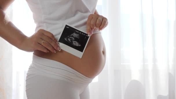 Březí samice drží skenovat budoucí dítě v blízkosti velké břicho close-up — Stock video