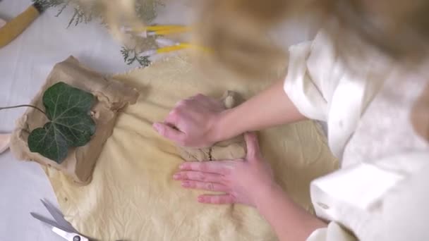 Cerámica, manos fuertes artesano mujer amasando arcilla en la mesa de trabajo para hacer platos de cerámica en la vista superior de la sala de trabajo — Vídeos de Stock