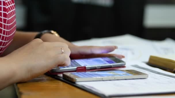 Vrouwen handen close-up maakt gebruik van een gadget aan een tafel — Stockvideo