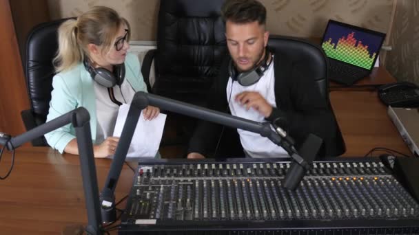 Άνδρας και γυναίκα με ακουστικά επικοινωνούν μεταξύ τους εκτός από μικρόφωνο — Αρχείο Βίντεο
