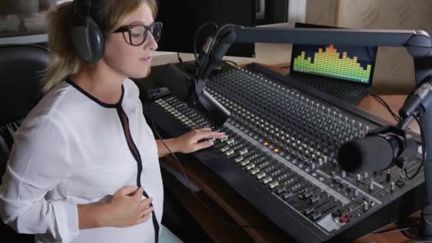 Pregnant woman in headphones at job, modern mom on harmful work — ストック動画