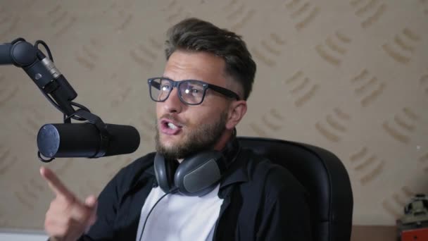 Portrait of young man in glasses works on radio show — Stock Video