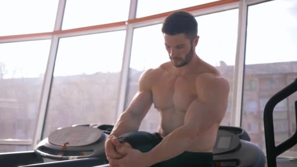 Здоровый образ жизни, привлекательный сильный спортсмен парень делает разминку после силовых тренировок в наращивании мышц в спортивном центре — стоковое видео