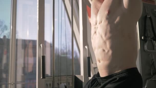 Svalnatý silný sportovec vlaky břišní svaly na baru v tělocvičně při posilovně cvičení zblízka na slunci — Stock video