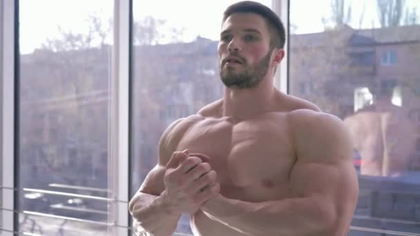 Estilo de vida deportivo, hermoso hombre fuerte culturista hace el calentamiento después del entrenamiento de energía en la construcción de músculo en el gimnasio — Vídeo de stock