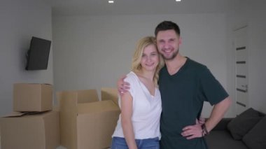 Yeni ev sahiplerinin portresi dairenin anahtarlarını gösteriyor ve kutuların arka planına yerleştirilirken sarılıyor.