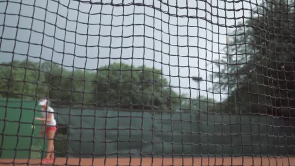 Triunfo deportivo, jugador de tenis exitoso adolescente golpea raqueta en la pelota y corre hasta la red con las manos arriba y saltando de la felicidad en la cancha — Vídeos de Stock