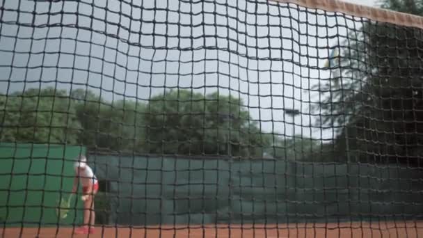 Deportes ganar, jugador de tenis profesional adolescente chica golpea raqueta en la pelota y corre hasta la red con las manos arriba y feliz en la cancha — Vídeos de Stock