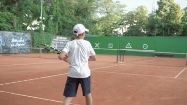 Profesyonel tenis, sporcu aktif çocuk rakipleriyle tenis oynuyor ve raket vuruyor. Maç sırasında kalede birbirinize pas atıyorsunuz.