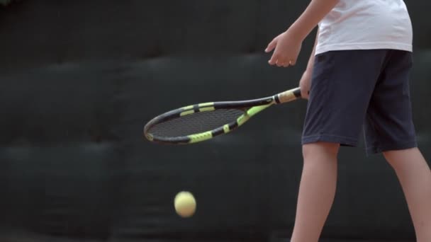 Ambitious determined tennis player teenager girl concentrating and focusing on game and hitting racket on ball at court in air — ストック動画