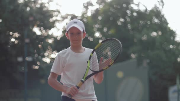 Портрет мальчика теннисиста, держащего теннисную ракетку на корте на открытом воздухе, профессиональный спорт — стоковое видео