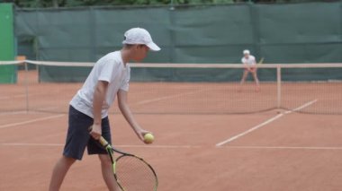 Tenis maçı, sporcu çocuk ve yarışmacı raketlerle raket vuruyor. Sarayda birbirlerine pas atıyorlar.