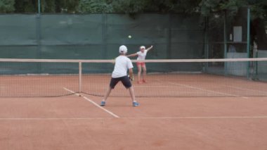 Tenis, sporcu, rakip genç çocuk rakip sahada raketlere vuruyor.