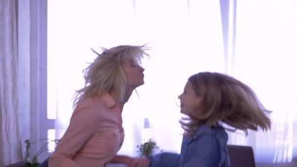 Glückliche Schwestern haben Spaß zusammen und springen zu Hause Händchen haltend aufs Bett — Stockvideo
