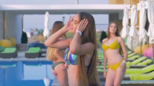 Dlouhosrsté šťastné přítelkyně do plavek tančících u bazénu v drahém letovisku během dovolené — Stock video