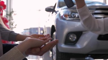 Otomobil işi, araba sahiplerinin aile işi satış merkezindeki otomobilin arka planında anahtarları al