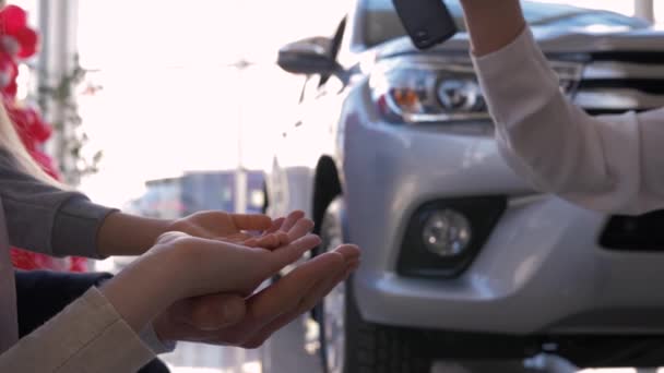 Auto business, family hands of owners car take keys on background of automobile close-up in sales center — Stock Video