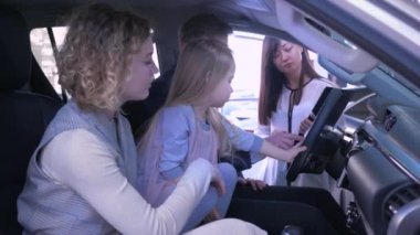 Aile ulaşımının satın alınması, küçük tatlı bir kızı olan genç bir çift araba satın alma konusunda otomobil merkezinde otururken satıcılarla iletişim kuruyor.