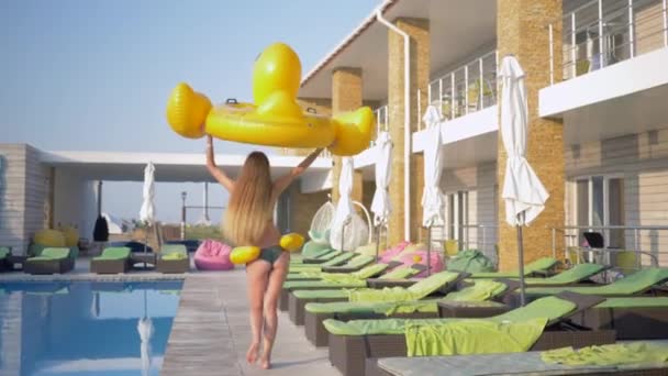 Літня відпустка, приваблива струнка дівчина з довгим волоссям і красивою здобиччю проводить весело час з щасливою відпусткою в басейні в сонячний день на розкішному курорті — стокове відео