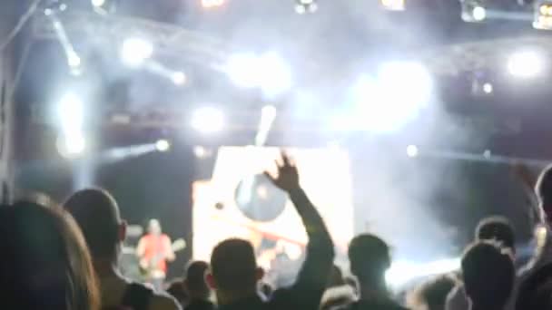Fans activos disfrutan de la música en vivo y saltar durante concierto espectáculo en luces brillantes — Vídeo de stock