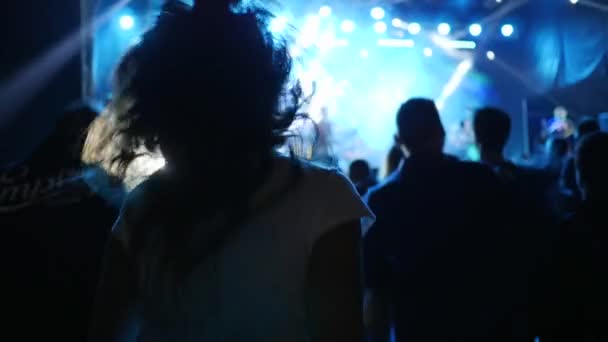 Persone stanno saltando e godere di musica dal vivo su festival rock in luci brillanti — Video Stock